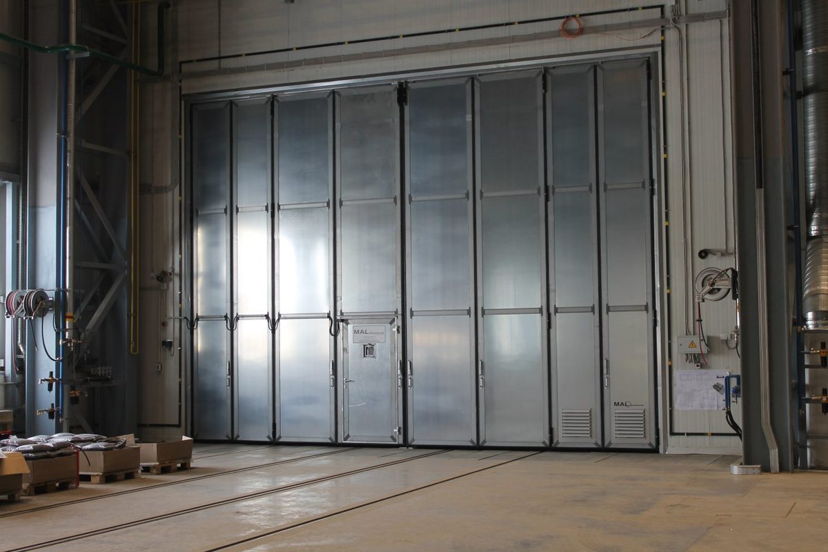 Blick in eine Strahlhalle mit verkleideten Wänden und Rostboden