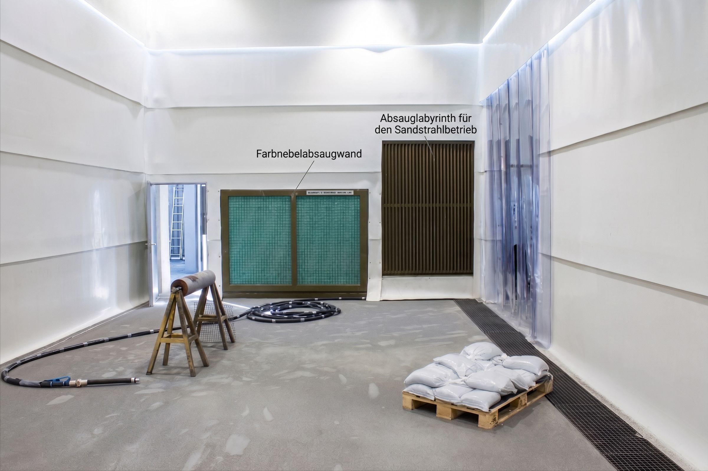 Innenraum einer Freistrahlhalle mit Beschichtungsplatz, Farbnebelabsaugwand und Absauglabyrinth für den Sandstrahlbetrieb